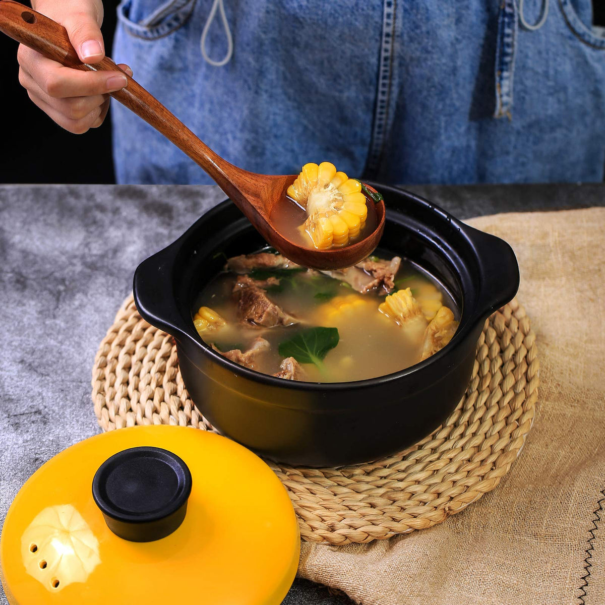 Wooden ladle being used to serve soup from a cooking pot