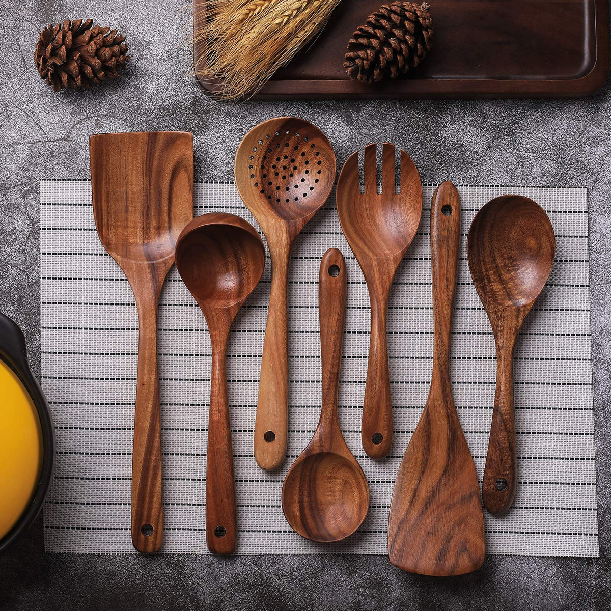 Complete seven piece teak cooking utensil set arranged together